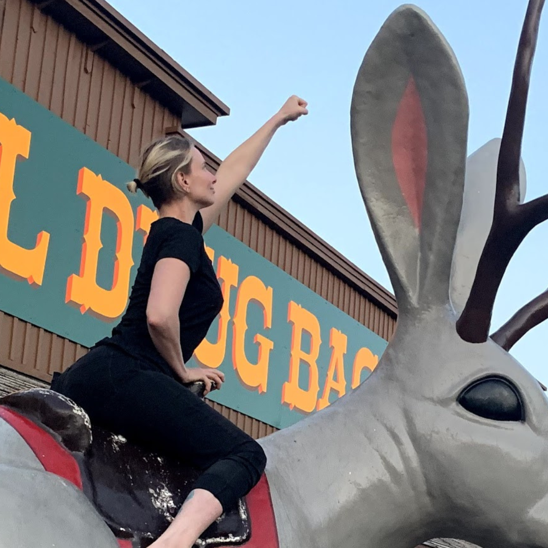 Cat Saint-Croix on a large rabbit statue outside of Wall Drug in North Dakota