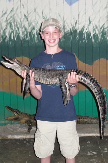 Kid holding an alligator