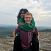 Levi Palmer gives a piggyback to a classmate at the top of a mountain